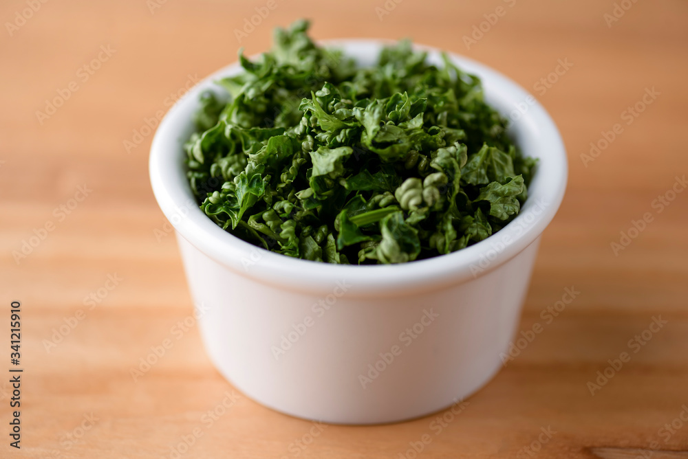 Bowl with tasty fresh greenery over rustic wooden table. Green onion in a bowl. Bowl with tasty fresh greenery over rustic wooden table. Green onion in a bowl.