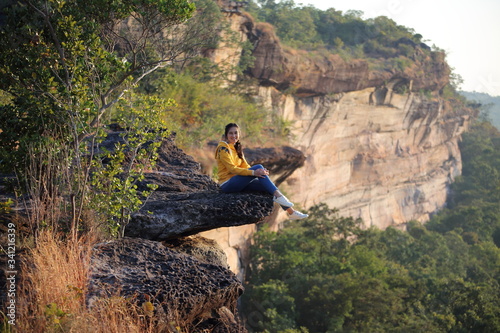 Woman sitting on the cliff at Pha Tam National Park, Ubon Ratchathani, Thailand.