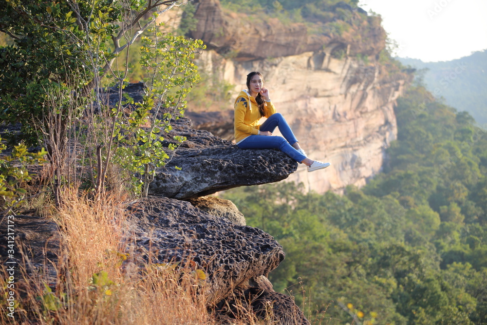 Woman sitting on the cliff at Pha Tam National Park, Ubon Ratchathani, Thailand.