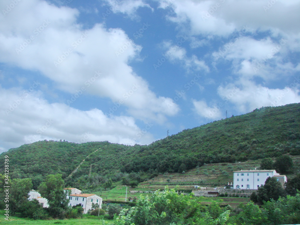 Obraz premium Panorama of green hills in the outskirts of Florence on a background of blue barely cloudy sky.