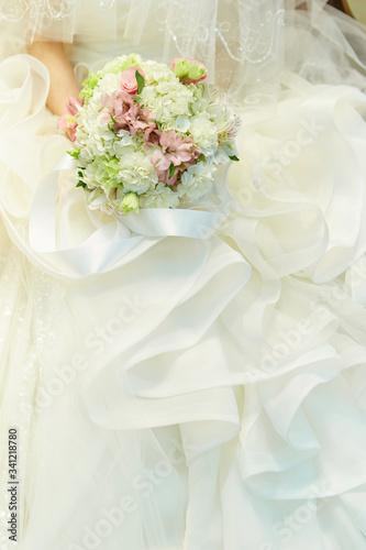 Bride in wedding dress holding flower bouquet 
