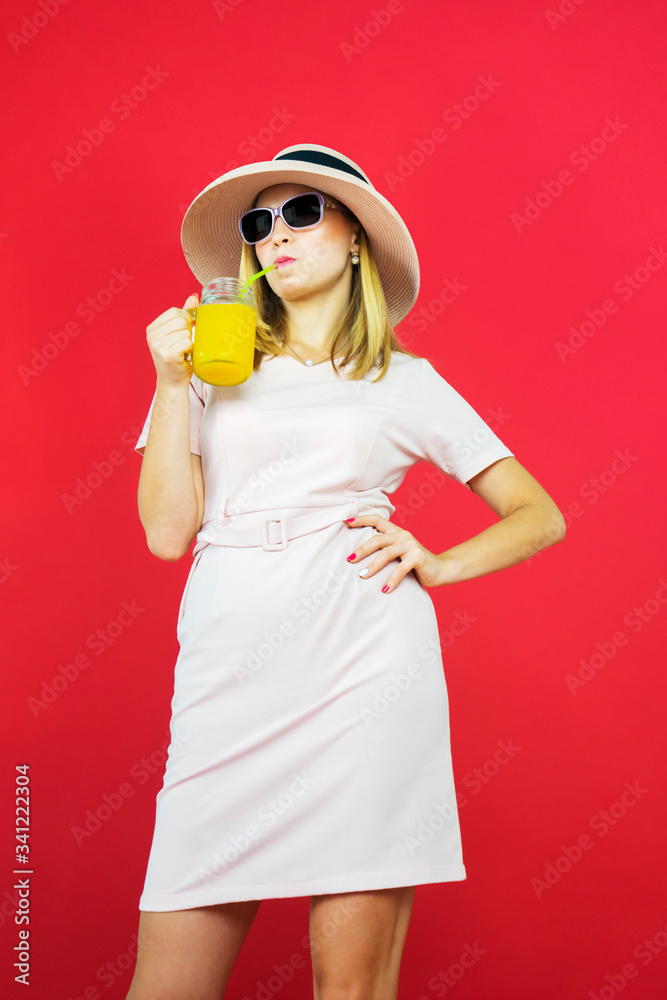 Young woman drinking a glass of juice in studio Young woman drinking a glass of juice in studio