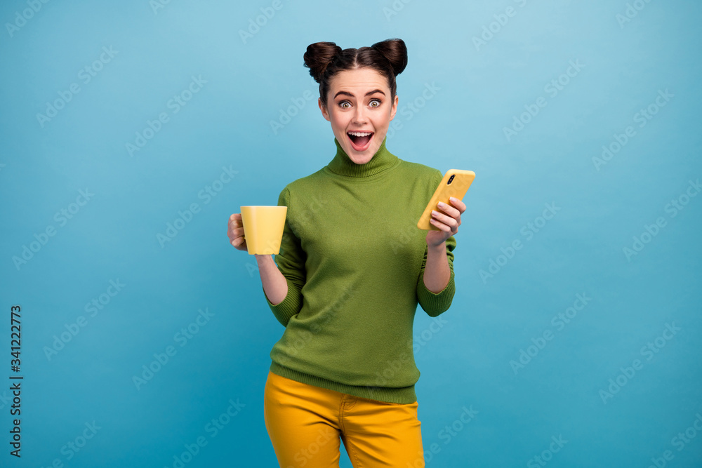 Photo of funny cheerful lady hold beverage mug freelancer work browsing telephone open mouth good news wear green turtleneck yellow pants isolated blue color background Photo of funny cheerful lady hold beverage mug freelancer work browsing telephone open mouth good news wear green turtleneck yellow pants isolated blue color background