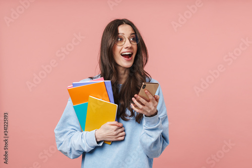 Image of woman using cellphone and holding exercise books isolated