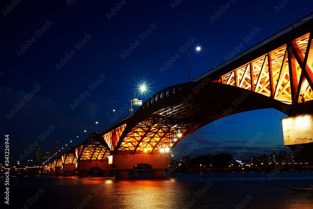 Obraz premium Lighting up bridge over the river 