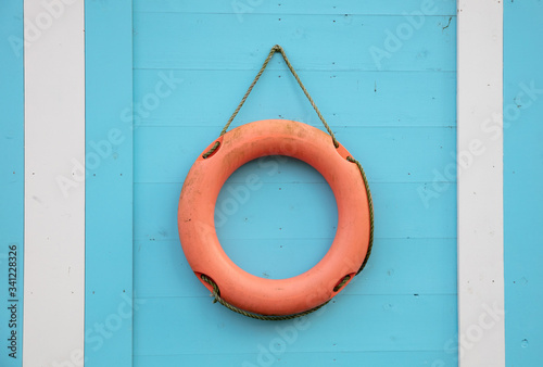 Orange lifebuoy hanging on a wall