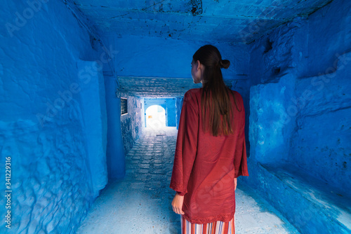 tourist in national dress of the east stands in the tunnel of the blue city of morocco © nelen.ru