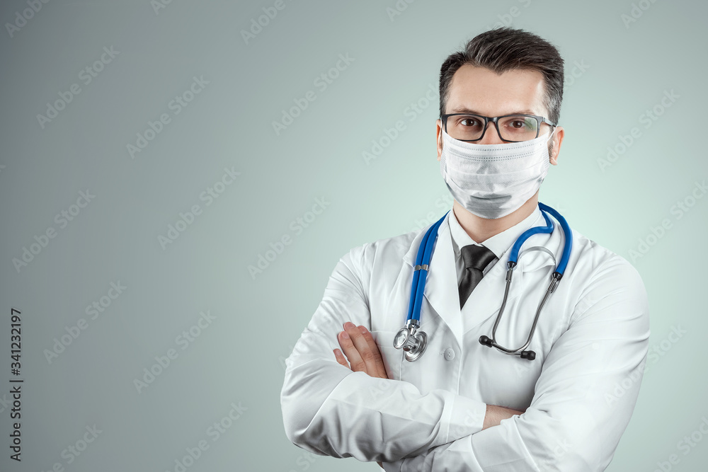 Doctor in a medical mask on a light background. The concept of a ban on leaving the house, self-isolation, quarantine, precautions, distance, COVID-19. Doctor in a medical mask on a light background. The concept of a ban on leaving the house, self-isolation, quarantine, precautions, distance, COVID-19.