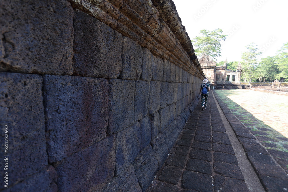 A woman by the wall of Prasat Mueang Tam (Mueang Tam castle) in Buriram, Thailand A woman by the wall of Prasat Mueang Tam (Mueang Tam castle) in Buriram, Thailand