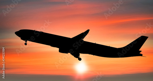 Airplane taking off after from the airport at sunset background, Silhouette of big passenger or cargo aircraft, airline, Business transportation banner or flyer for travel and vacation design concept.