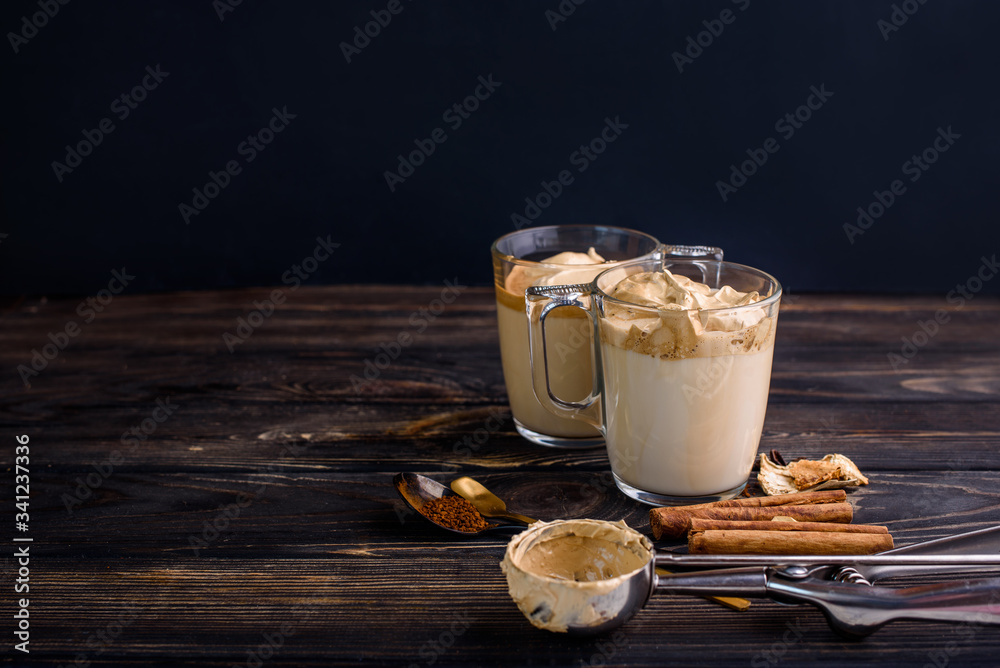 Delicious and fragrant dalgona coffee in glass cups, cinnamon sticks, dried mushrooms, a spoon of instant coffee, sugar. Delicious and fragrant dalgona coffee in glass cups, cinnamon sticks, dried mushrooms, a spoon of instant coffee, sugar.