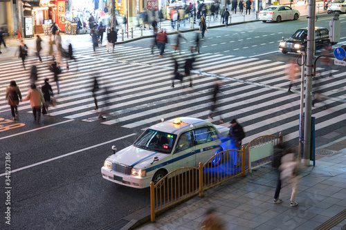 Man getting into taxi and pedestrians at crosswalk in Tokyo タクシーに乗り込む男性と横断歩道を渡る人々 夜の東京