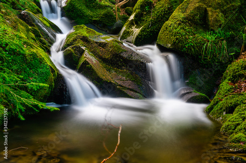 Long time exposure of a small waterfall with cascades in the heart of the Black Forest with beautiful color mood in spring