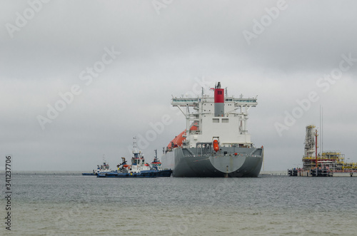 LNG TERMINAL AND GAS TANKER - A large ship maneuvers into the unloading quay 