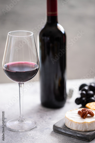 Red wine glass and cutting board with different snacks for wine,grapes,cheese and crackers. Wine lover concept