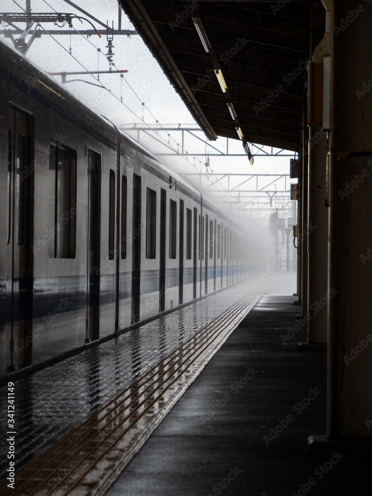 A train pulling into a station in heavy rain