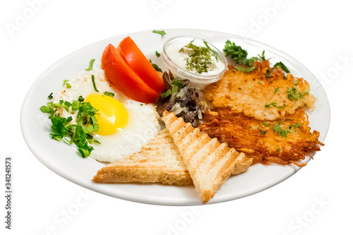 Full breakfast on a white background. Fried eggs, fried mushrooms, hash browns, potato pancakes, toasts and fresh tomato. Isolated object
