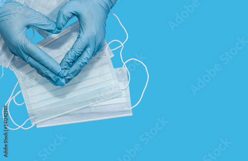 Protective medical white face mask on a blue background. View from above. Space for text. Close up, gorizontal orientation