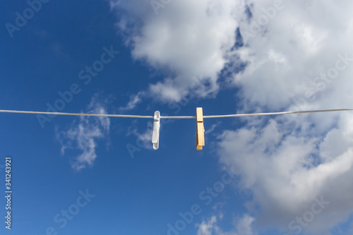 Wooden and plastic clothespins hanging on a cable