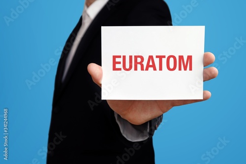 EURATOM. Geschäftsmann im Anzug hält Karte in die Kamera. Der Begriff EURATOM steht im Schild. Symbol für Business, Finanzen, Statistik, Analyse, Wirtschaft photo