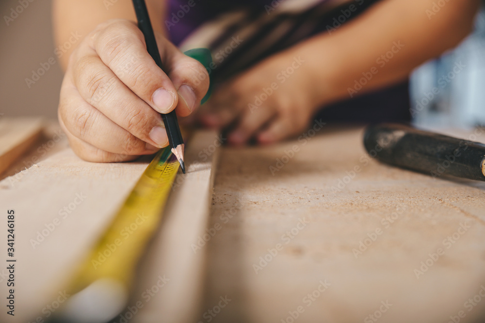 Carpenter in the workshop marks on wooden board in workshop Carpenter in the workshop marks on wooden board in workshop