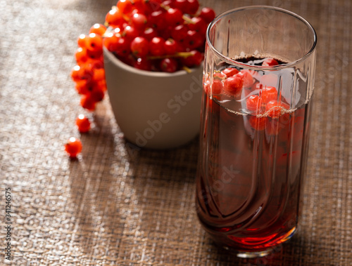Red currant beverage and fresh fruit in moody sunset lighting