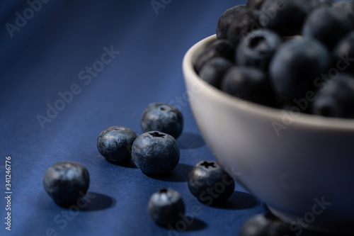 Cup of fresh blueberry fruit in dark and moody lighting