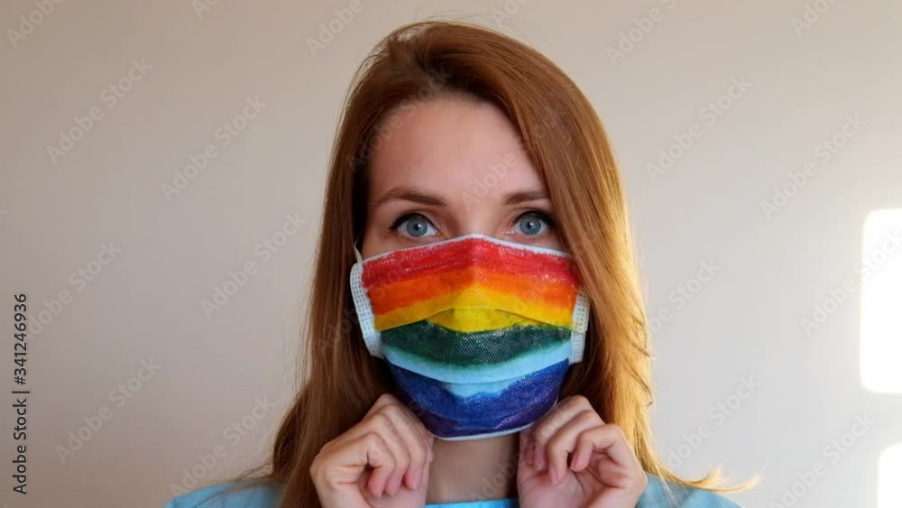 Portrait of a doctor in a mask, on which a rainbow is drawn as a sign of hope of victory over a coronovirus infection. Portrait of a doctor in a mask, on which a rainbow is drawn as a sign of hope of victory over a coronovirus infection.