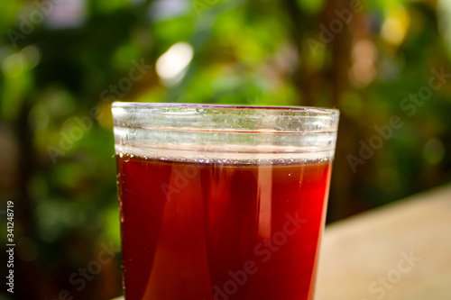 Outdoor Tea pouring into glass cup transparent with day sunlight.
