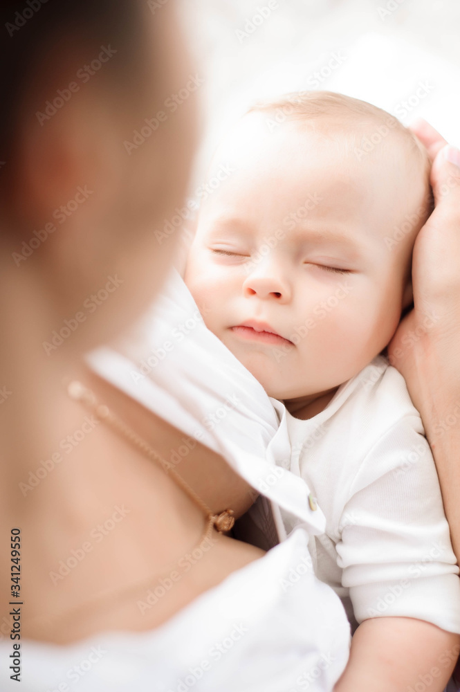Baby sleeping on the mother's chest. Young mother cuddling baby Baby sleeping on the mother's chest. Young mother cuddling baby