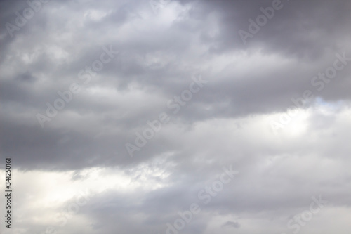 Clouds in the blue sky. A stunning gray sky. The storm is approaching. A beautiful clouds against the blue sky background. Amazing cloud pattern in the sky.