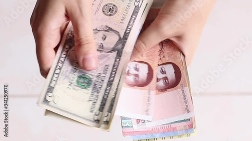 Woman traveler's hands recounts her cash money in different currencies