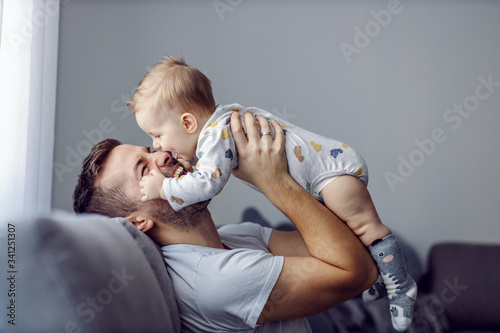 Принти на полотні Adorable little blond boy playing with his caring father and biting his nose
