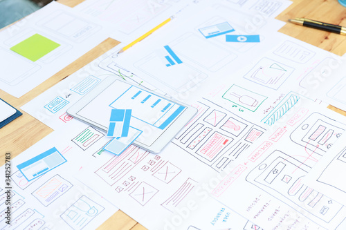 Graphic designers work together with UX UI designer planning application template layout framework for mobile phone computer mobile