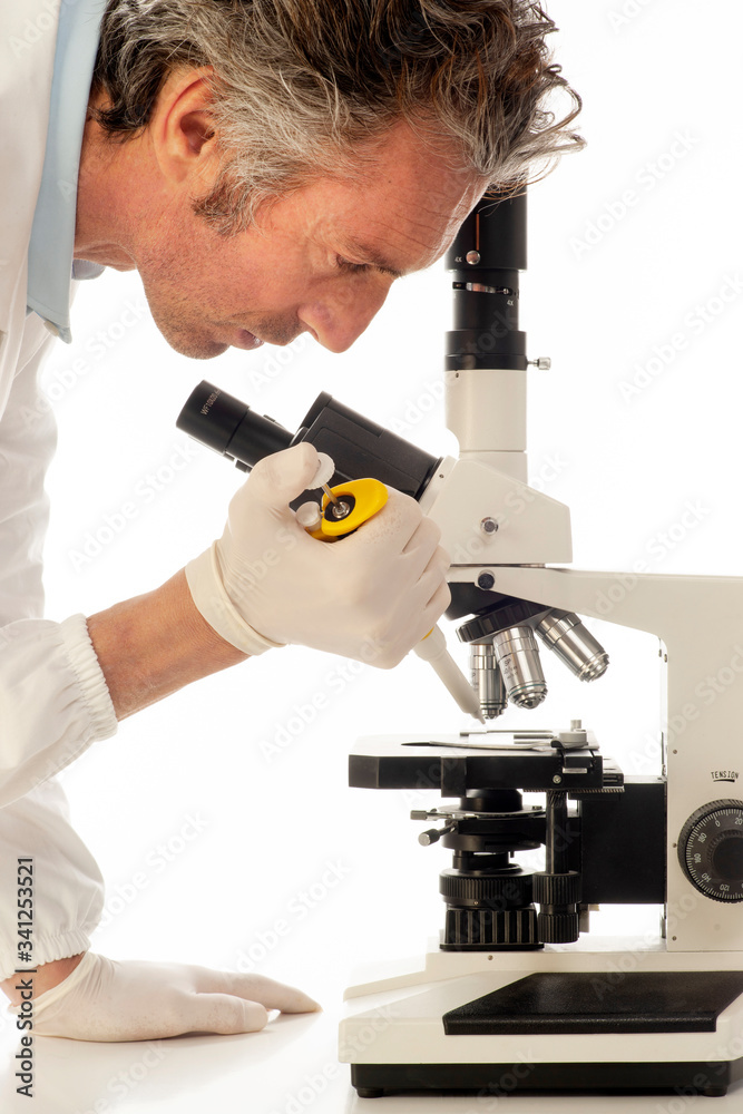 A doctor who is analyzing laboratory samples under a microscope A doctor who is analyzing laboratory samples under a microscope