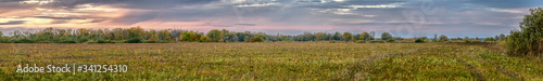 Clouds in the sky over autumn meadow and forest