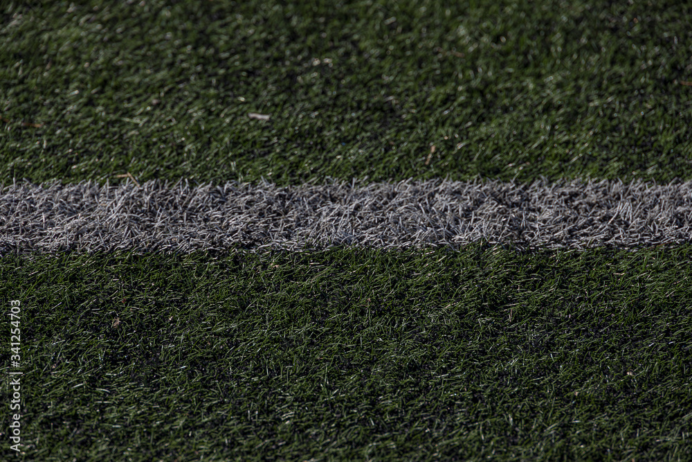  green background of artificial turf football field in closeup