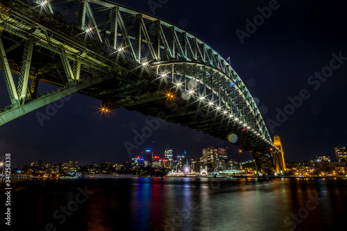 Sydney, Australia - 12th February 2020: A German photographer visiting Sydney in Australia, taking pictures of the Harbour Bridge at night with the Lunar park in the background.