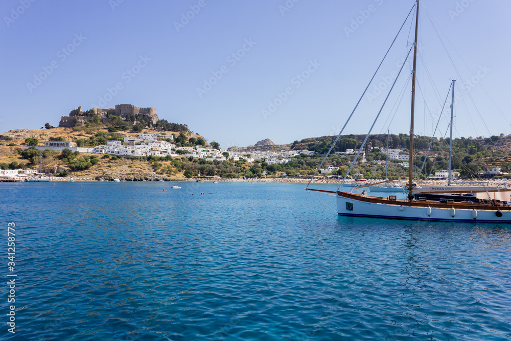 Lindos Village in Rhodes, Greece - 07/07/2018 : view of a yacht in the sea.