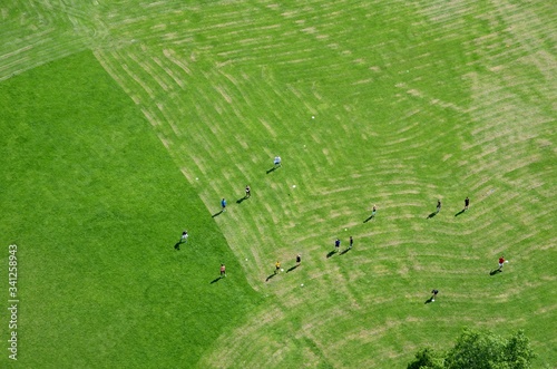 Young people play frisbee on a green field near the Danauturm tower in Vienna.