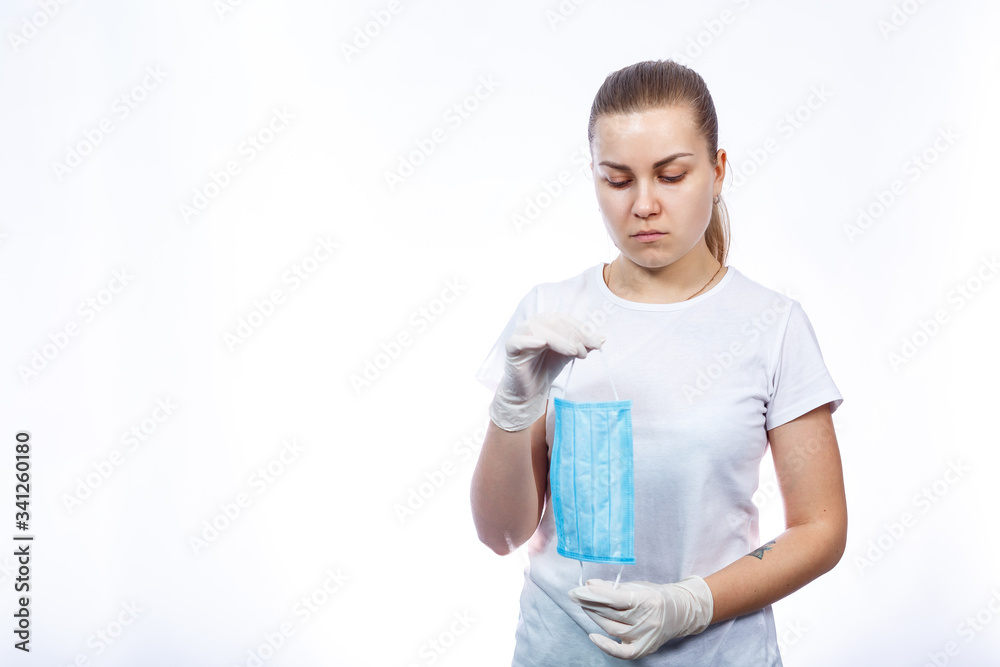 woman health worker demonstrates how to wear a protective medical surgical mask against the virus. Isolated on white background woman health worker demonstrates how to wear a protective medical surgical mask against the virus. Isolated on white background