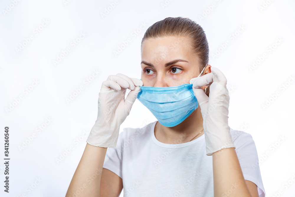 woman health worker demonstrates how to wear a protective medical surgical mask against the virus. Isolated on white background woman health worker demonstrates how to wear a protective medical surgical mask against the virus. Isolated on white background
