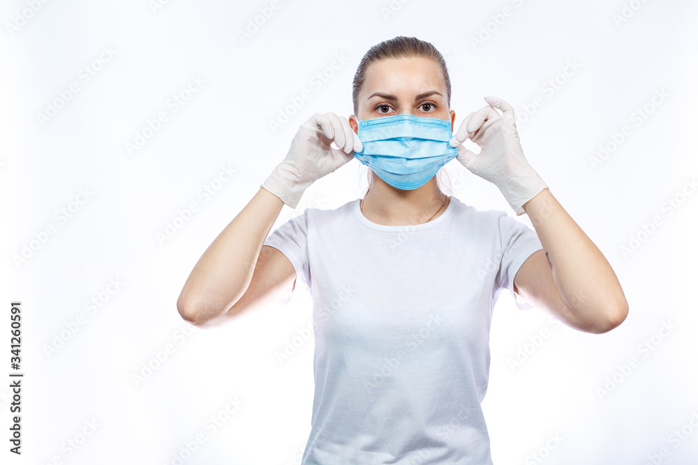 woman health worker demonstrates how to wear a protective medical surgical mask against the virus. Isolated on white background woman health worker demonstrates how to wear a protective medical surgical mask against the virus. Isolated on white background