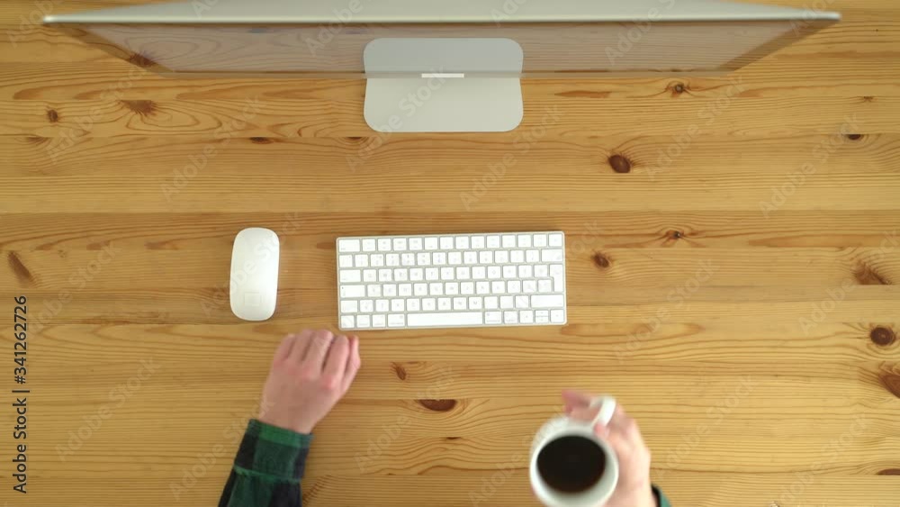Image from above of left-hand man working from home during the day. Image from above of left-hand man working from home during the day.