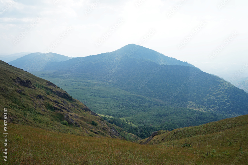 Natural landscape of green mountain range with cloudy blue sky