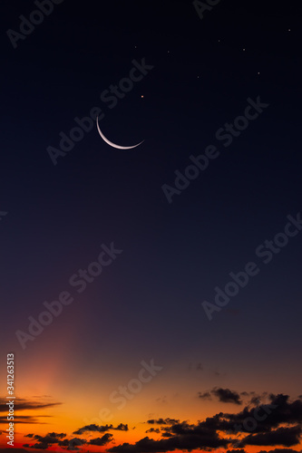 crescent moon and stars on dark sky vertical photo