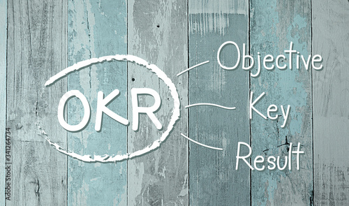 OKR - Objective Key Results acronym, New business concept on blurred texture of blue wooden background