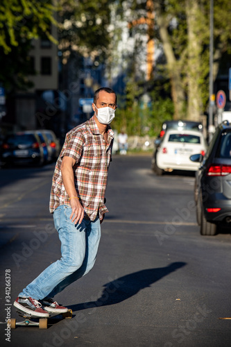Man skateboarding using face mask in street at sunny day