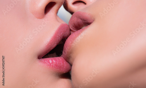 Two women kissing. Lesbian couple kiss lips. Sexy lesbian lovers foreplay. Closeup of women mouths kissing. photo