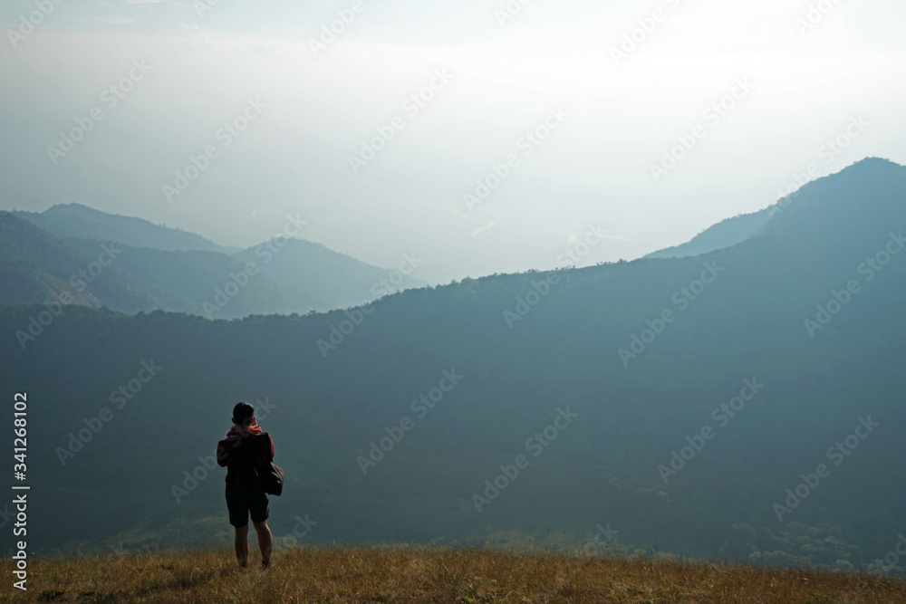 A girl taking a photo among natural green mountain range